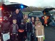 Foto de la oficial Elizabeth Deitelhoff con niños disfrazados en el evento Halloween Trunk or Treat.