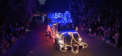 lit utility truck and walkers in the parade
